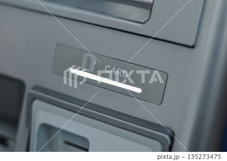 ATM Card Slot Illuminating with Natural Light, Providing Copy Space for Financial Service Advertising and Banking Solutions 135273475