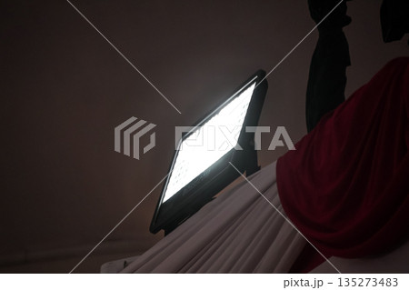 LED panel light illuminating fabric with copy space, promoting product photography under natural lighting in a studio setting. LED panel light illuminating fabric with copy space, promoting product photography under natural lighting in a studio setting. 135273483
