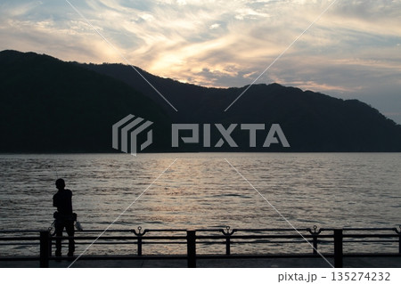 夕暮れの海と釣り人のシルエット 135274232