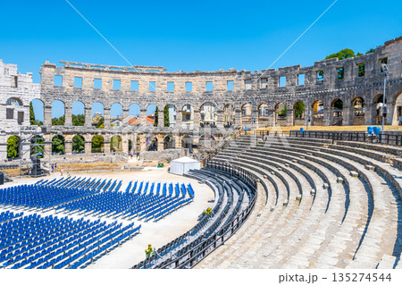 The Roman amphitheatre in Pula showcases ancient architecture, with its stone structure and seats arranged for an event. The Roman amphitheatre in Pula showcases ancient architecture, with its stone structure and seats arranged for an event. 135274544