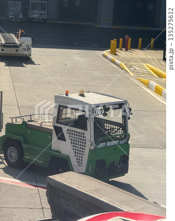 Airport ground service vehicle near terminal building. Aviation logistics, ground handling, and operational support through transport equipment 135275612