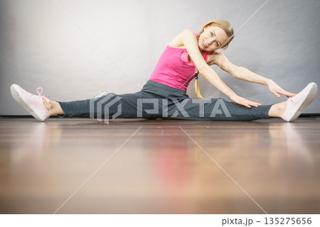 Woman in sportswear stretching legs 135275656