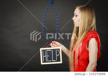 Suicidal woman holding help sign next to rope Suicidal woman holding help sign next to rope 135275699