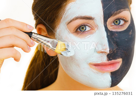 Girl black mask on half face apply white mud 135276031