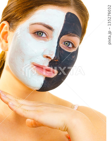 Girl with black white mud mask on face Girl with black white mud mask on face 135276032