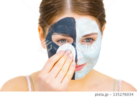 Girl remove black white mud mask from face Girl remove black white mud mask from face 135276034