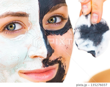 Girl remove black white mud mask from face Girl remove black white mud mask from face 135276037