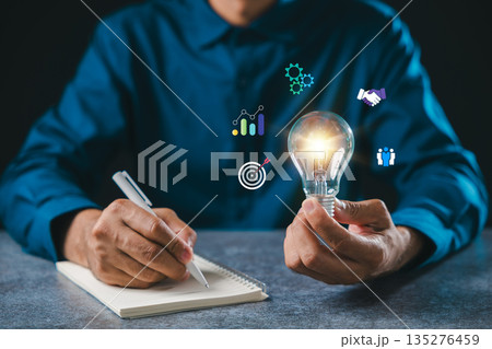 Creative bulb mindset light idea concept lightbulb business innovation, professional writes notes while planning strategy using colorful icons for insight and future success Creative bulb mindset light idea concept lightbulb business innovation, professional writes notes while planning strategy using colorful icons for insight and future success 135276459