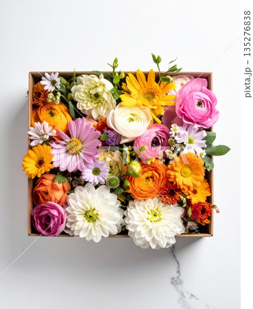 A colorful spring garden arrangement of pink and orange rose blossoms in a beautiful floral gift bouquet or wooden box decoration 135276838