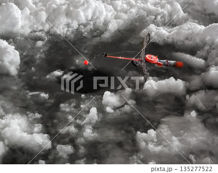 Fishing through ice in winter on a frozen lake with gear set up for a catch 135277522