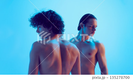 Two young men back view with emotional contrast in blue light. 135278700