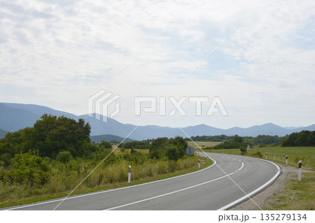 Winding asphalt road through Lika mountains in Croatia 135279134