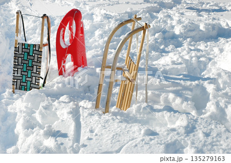 Various sleds and bobsled in deep fresh snow Various sleds and bobsled in deep fresh snow 135279163