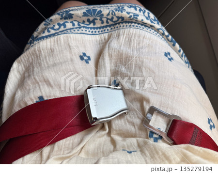 Aircraft seat belt opened on passenger seat. Inflight readiness, movement freedom, and cabin transition through aviation safety equipment Aircraft seat belt opened on passenger seat. Inflight readiness, movement freedom, and cabin transition through aviation safety equipment 135279194