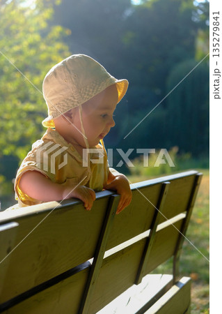 Toddler in Sun Hat at Park Bench Toddler in Sun Hat at Park Bench 135279841