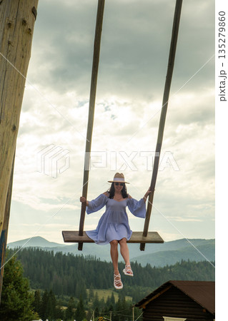 Woman Swinging Over Scenic Mountain Landscape Woman Swinging Over Scenic Mountain Landscape 135279860