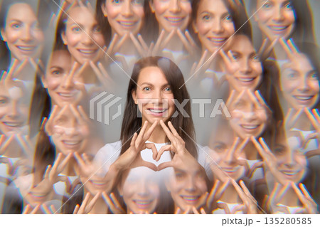 Surreal creative portrait of woman making heart shape with fingers Surreal creative portrait of woman making heart shape with fingers 135280585