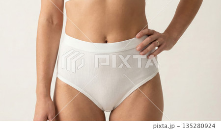 Close-up, textured studio shot of a woman's thigh and hip area, showcasing smooth 135280924