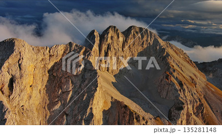Amazing rocky mountains in clouds at sunset Amazing rocky mountains in clouds at sunset 135281148