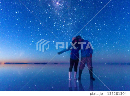 ボリビアのウユニ塩湖で星空を見上げるカップル 135281304