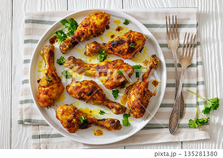 roasted chicken drumsticks on a white plate roasted chicken drumsticks on a white plate 135281380