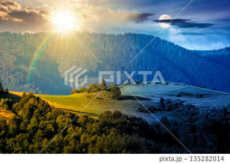 mountainous countryside landscape with rolling hills on summer solstice. day and night time change concept. rural area with sun and moon at twilight. beautiful view for equality and shift template 135282014