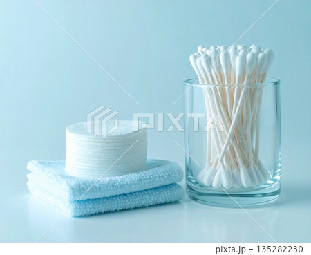 Cotton tools to remove makeup and cleanse the skin. White cotton swabs and reusable cotton pads neatly stacked on a white background. 135282230