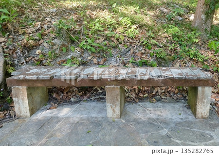 Weathered Wooden Bench in Serene Garden Setting Weathered Wooden Bench in Serene Garden Setting 135282765