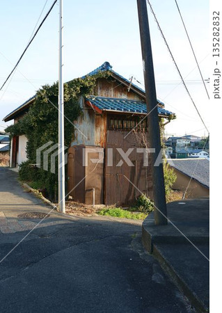雑草の生えたツタの絡んだ廃屋古い家 135282832