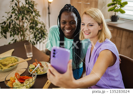 Enjoying a joyful lunch together in a sunny caf Enjoying a joyful lunch together in a sunny caf 135283024