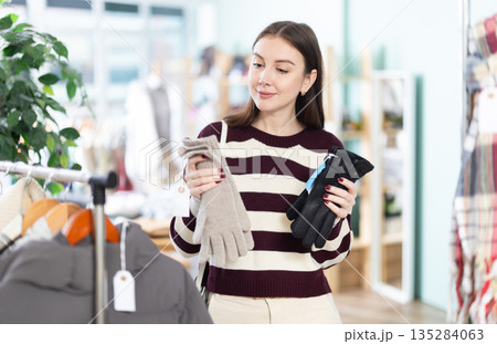 Young woman choosing gloves in clothing store Young woman choosing gloves in clothing store 135284063