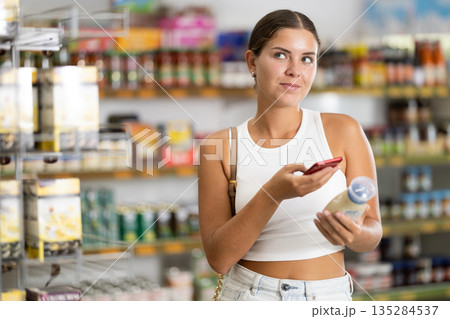 Young woman scanning qr code for mayonnaise 135284537