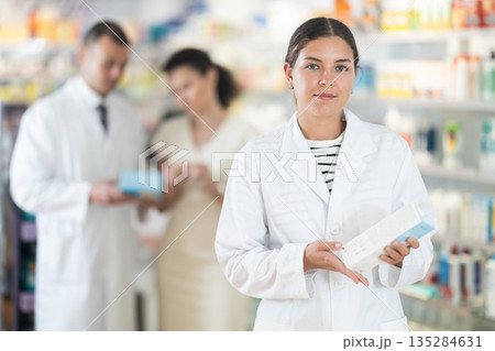 Female pharmacist in medical uniform posing while working in pharmacy 135284631