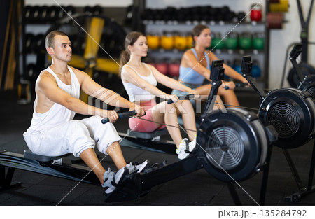 Sportsman training at cable row machine in modern crossfit gym 135284792