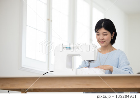 リビングでミシンがけをするミドル女性 135284911