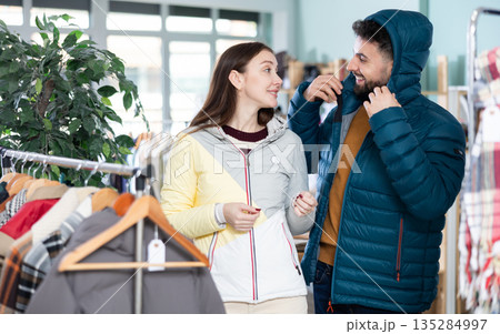 In store, couple try on down jacket 135284997