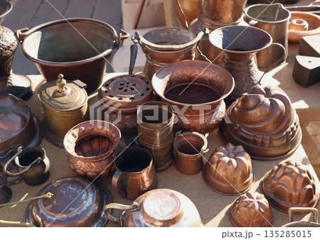 Antique flea market in Europe, Italy. Vintage items. Set of old copper tableware. Retro baking tins, coffee, drinks, background for design. Antique flea market in Europe, Italy. Vintage items. Set of old copper tableware. Retro baking tins, coffee, drinks, background for design. 135285015