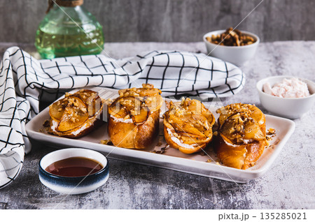 Sweet sandwiches with ricotta, baked pear, honey and nuts on a plate on the table 135285021