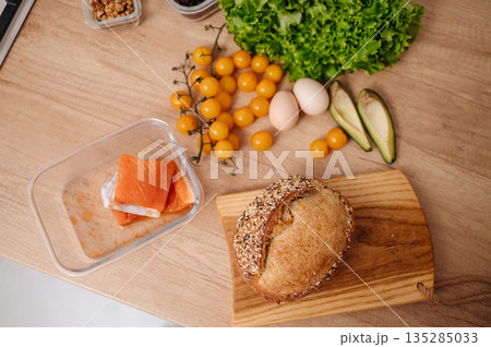 Healthy breakfast cooking with salmon eggs avocado and vegetables on table 135285033