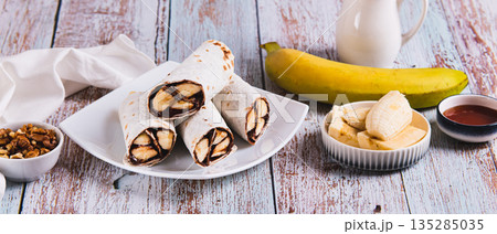 Sweet rolls with chocolate and banana on a plate on the table web banner Sweet rolls with chocolate and banana on a plate on the table web banner 135285035