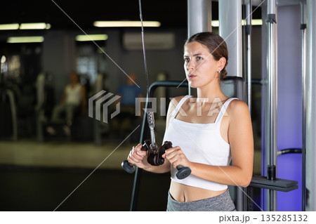 Young woman training with straps in gym Young woman training with straps in gym 135285132