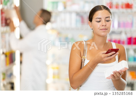 Young girl customer scanning QR of medical product Young girl customer scanning QR of medical product 135285168