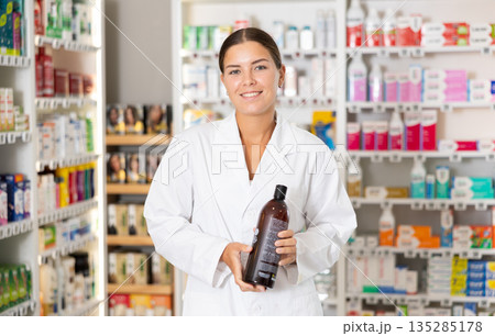 Young female pharmacist offering shampoo Young female pharmacist offering shampoo 135285178