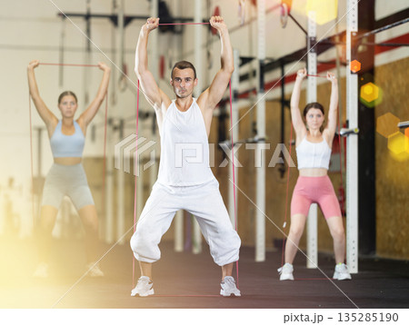 Young man exercising with elastic band Young man exercising with elastic band 135285190