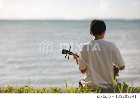 海辺で音楽を聴く男性 135285241