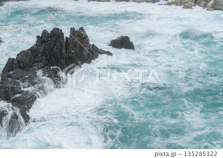 Powerful sea waves crashing against dark coastal rocks. Natural energy, dramatic seascape and ocean background 135285322