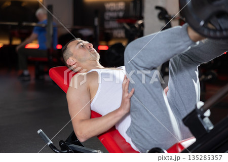 Athlete pulls his legs to his chest on special simulator Athlete pulls his legs to his chest on special simulator 135285357