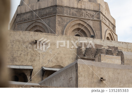 Historic Qalawun Complex in Cairo, featuring intricate architecture, tall minarets, and domes under a blue sky with clouds. A significant cultural landmark on Al-Muizz Street. 135285383