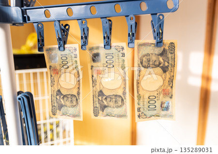 汚れた千円札を物干しスタンドで干している 汚れた千円札を物干しスタンドで干している 135289031