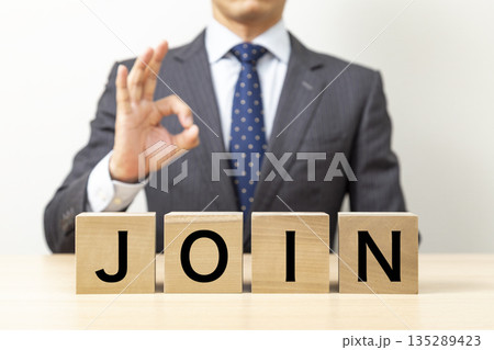 「JOIN」と書かれたブロックとOKポーズをするビジネスマン 135289423